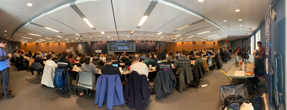 People in a room looking at a stage.