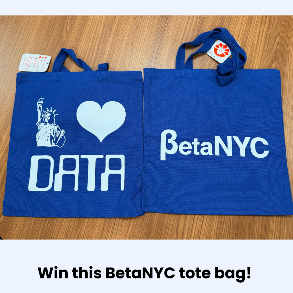 Two blue tote bags with the Statue of Liberty and heart icons and the words "data and BetaNYC" lie on a wooden table.