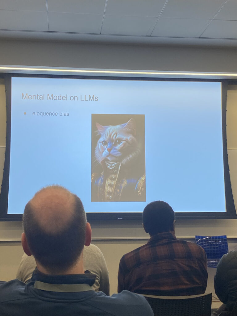 Soumith Chintala’s presentation including a meme of a cat to portray eloquence bias in Large Language Models (LLMs). 